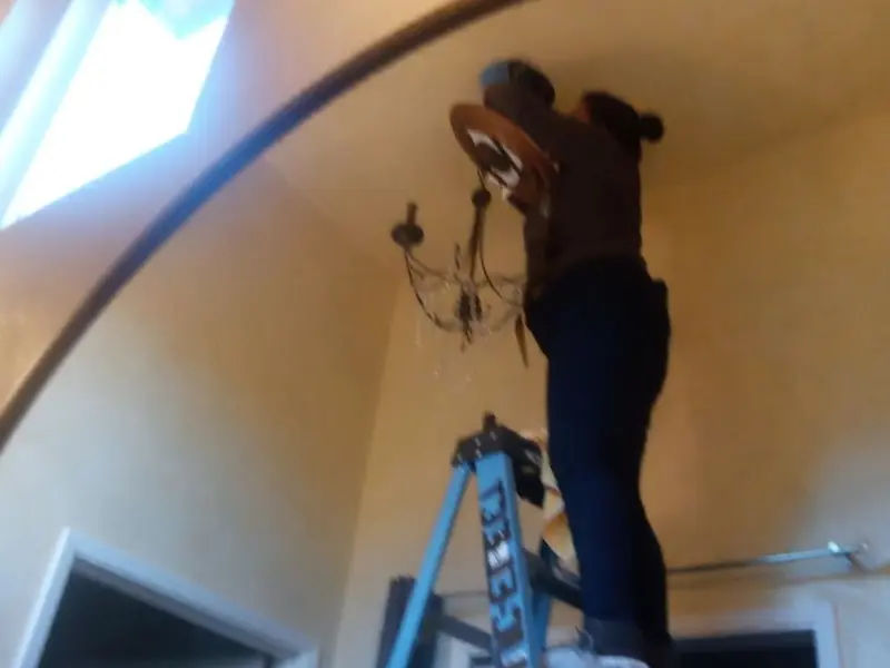Electrician installing a chandelier in a Rutland residence